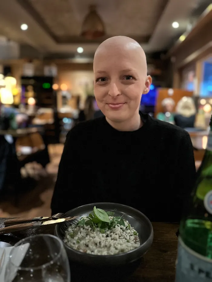 Sarah Reimann lächelnd beim Essen mit Freunden, während der Chemotherapie
